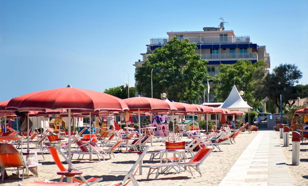 - un bouquet de chaises et de parasols sur une plage dans l'établissement Hotel LaMorosa, à Rimini