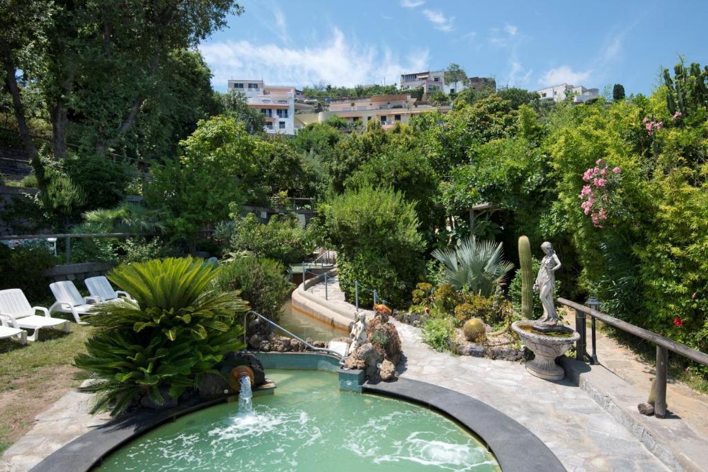 une piscine dans un jardin avec une fontaine dans l'établissement Hotel Giardino Delle Ninfe E La Fenice, à Ischia
