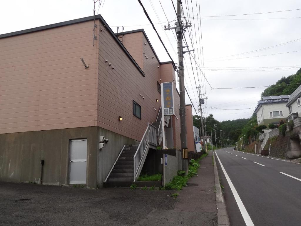un bâtiment avec des escaliers sur le côté d'une rue dans l'établissement Hotel Sango (Adult only), à Muroran
