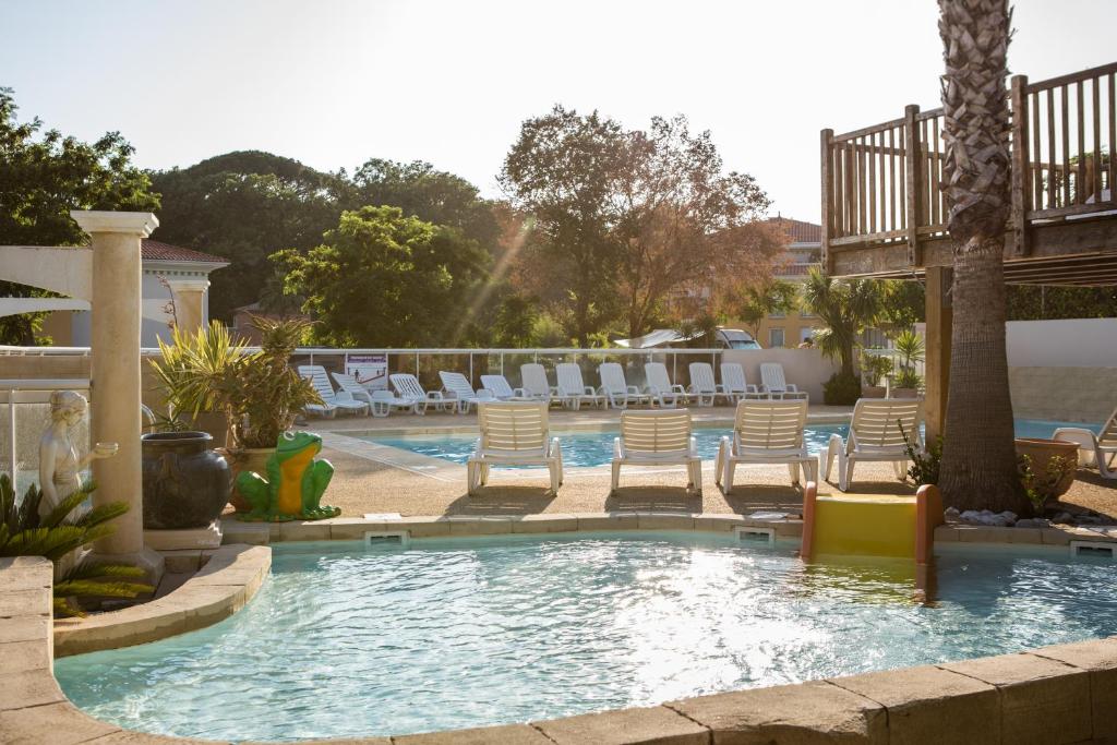 une piscine avec des chaises longues dans un complexe hôtelier dans l'établissement Camping les Acacias, à Fréjus