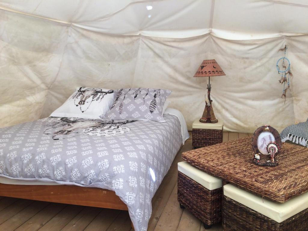 - une chambre avec un lit et une table dans une tente dans l'établissement Tipis nature, à Gavarnie