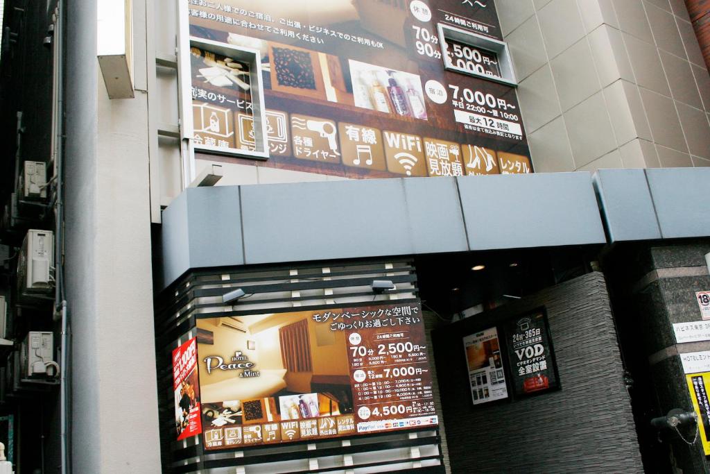 un bâtiment avec des panneaux sur le côté dans l'établissement Hotel Peace (Adult Only), à Tokyo