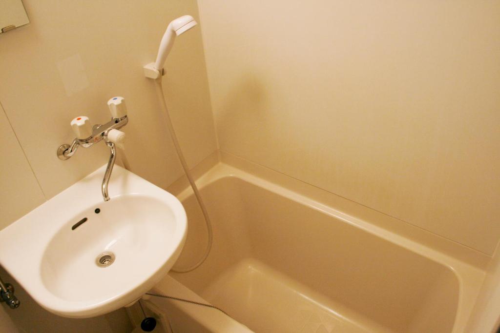 une salle de bain avec un lavabo, des toilettes et une baignoire dans l'établissement Hotel Peace (Adult Only), à Tokyo