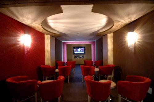 une salle d'attente avec des chaises rouges et une télévision à écran plat dans l'établissement Mediterraneo Palace Hotel, à Amantea 7 autres photos