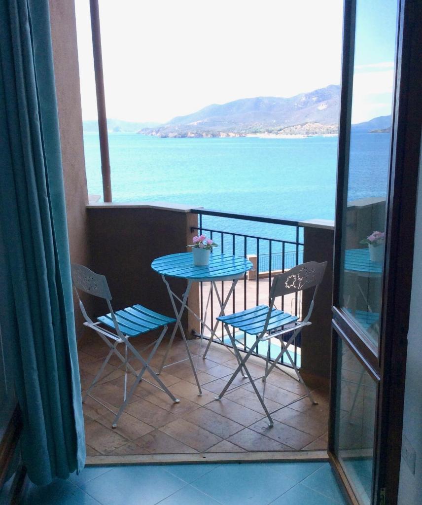un balcon avec une table et des chaises et l'océan dans l'établissement Apartment on the sea, à Cagliari