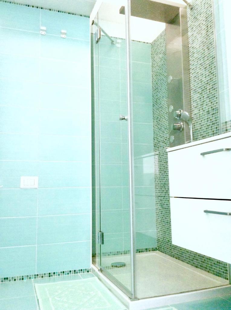 une douche avec une porte vitrée dans une salle de bain dans l'établissement Apartment on the sea, à Cagliari