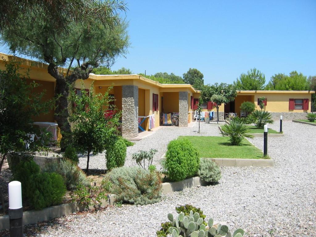 une rangée de cottages avec des plantes dans un jardin dans l'établissement Residence Torre Saracena, à Villapiana