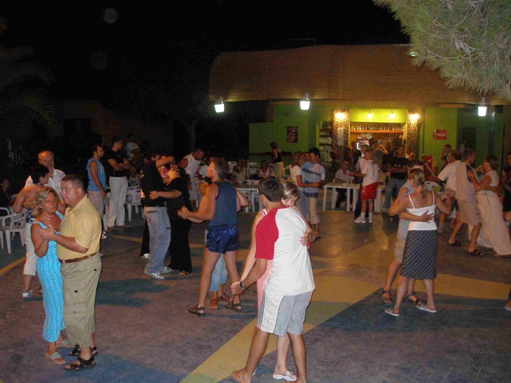 un groupe de personnes dansant à une fête la nuit dans l'établissement Residence Torre Saracena, à Villapiana
