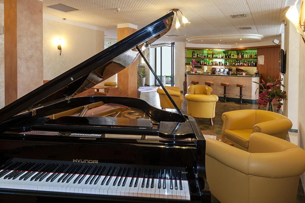 - un piano dans une pièce avec un bar dans l'établissement Regent's Hotel, à Lido di Jesolo