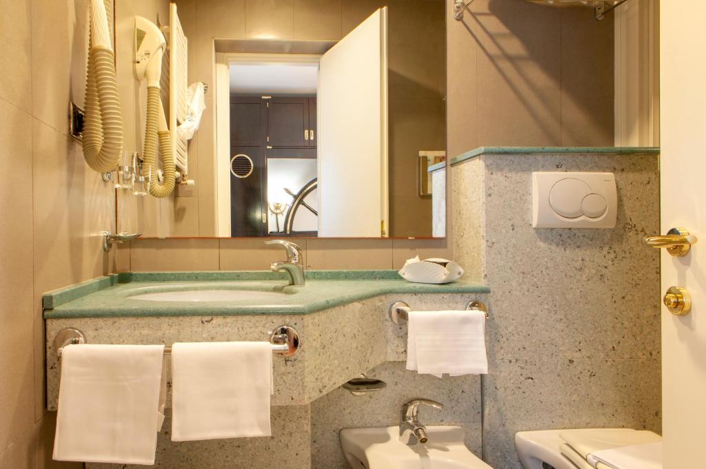 une salle de bain avec un lavabo et un miroir dans l'établissement Hotel Villa Lo Scoglietto, à San Vincenzo 20 autres photos