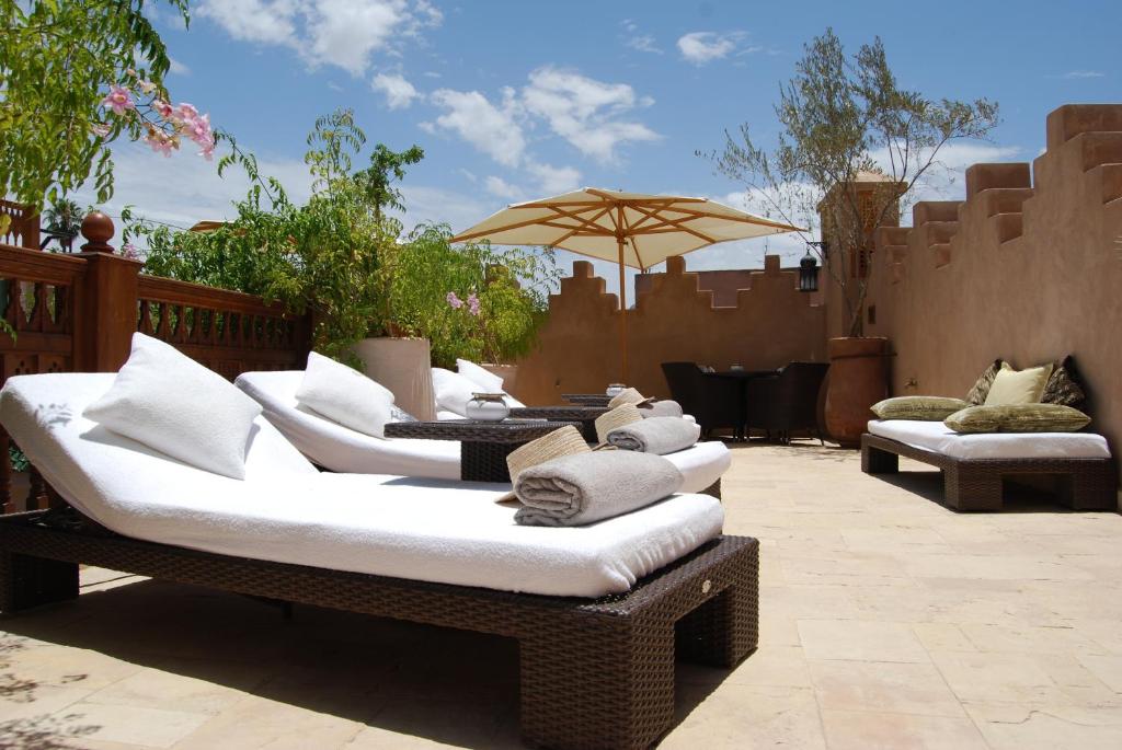 - un ensemble de canapés et d'un parasol sur la terrasse dans l'établissement Riad Flam & Spa, à Marrakech