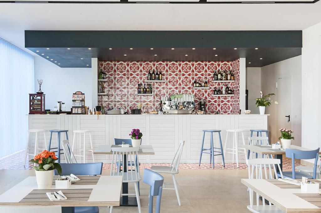 un restaurant avec des tables et des chaises et un bar dans l'établissement Modica Beach Resort, à Marina di Modica