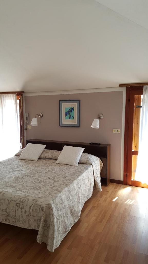 une chambre avec deux lits et un parquet dans l'établissement Hotel Marietta, à Caorle