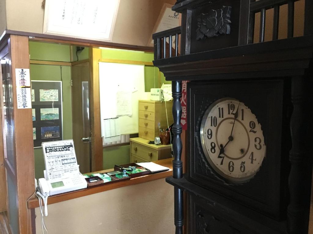une horloge grand-père assise dans une pièce dans l'établissement Masugataya Ryokan, à Tako