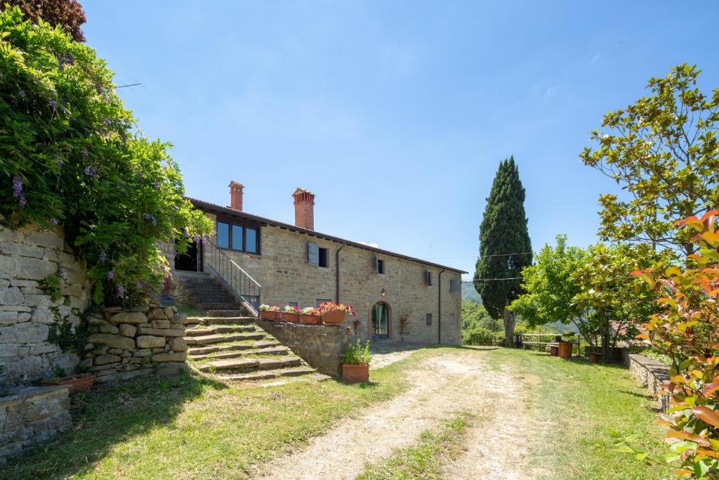 - une vue extérieure sur une maison en pierre avec des escaliers dans l'établissement Casale Mazzini by VacaVilla, à San Godenzo