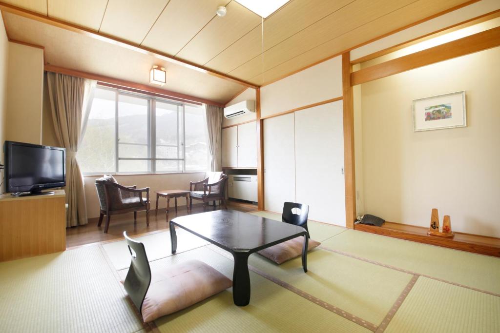 un salon avec une table et une salle à manger dans l'établissement Matsukaneya Annex, à Zao Onsen