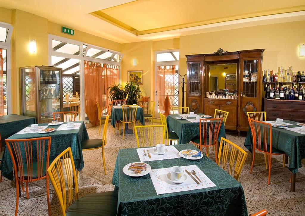 un restaurant avec des tables et des chaises vertes et une salle dans l'établissement Hotel Ristorante Miramare, à Pesaro