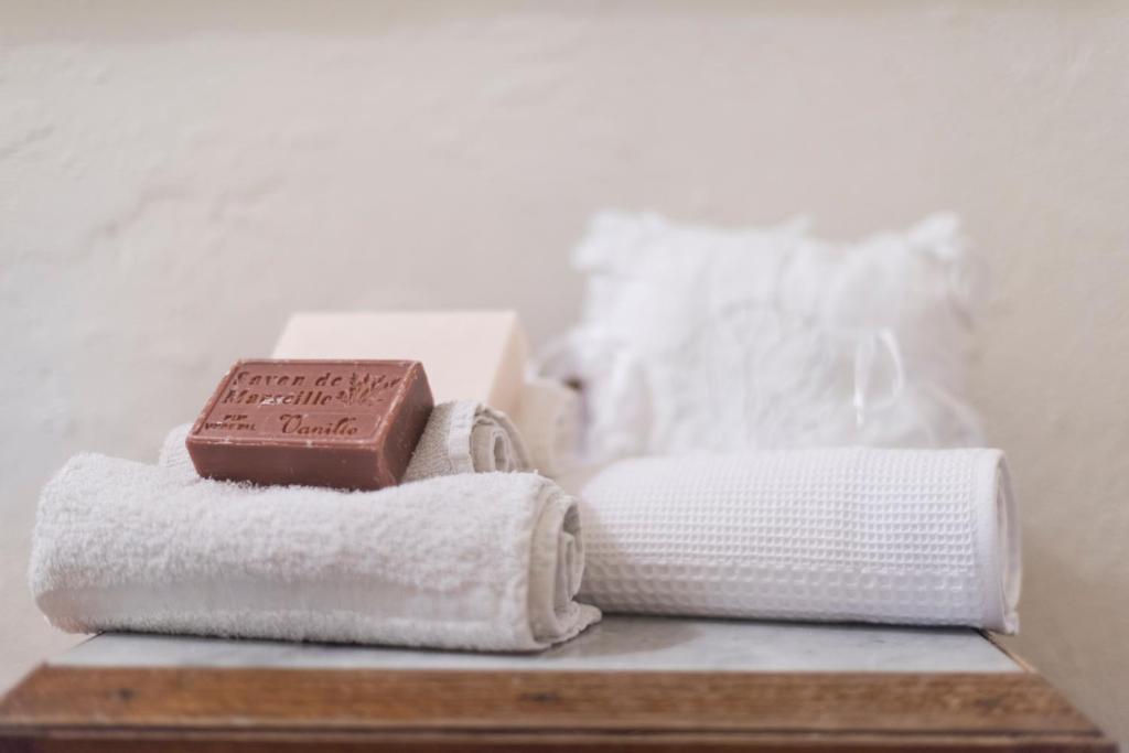 - une pile de serviettes et une barre de chocolat sur une table dans l'établissement Charming farmhouse in the hills, private pool, sea view, dream panorama, à Camaiore