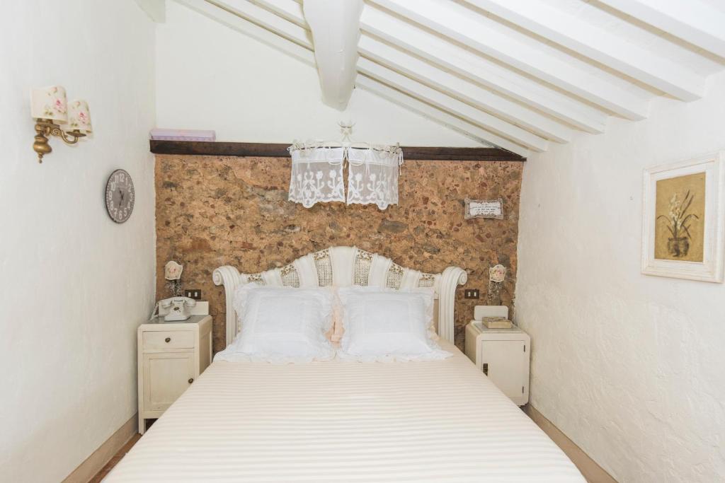 une chambre avec un lit blanc avec deux tables de nuit dans l'établissement Charming farmhouse in the hills, private pool, sea view, dream panorama, à Camaiore 113 autres photos