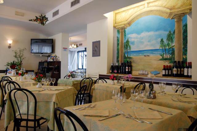 un restaurant avec des tables et des chaises et un tableau au mur dans l'établissement Hotel Rivamare, à Massignano