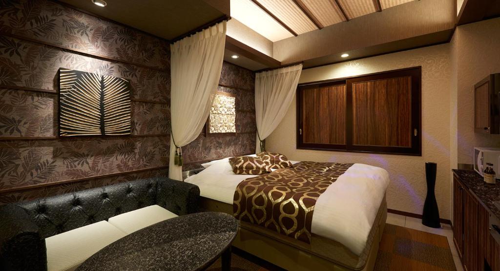 une chambre avec un lit, une chaise et un canapé dans l'établissement HOTEL EXE (Adult Only), à Tokyo