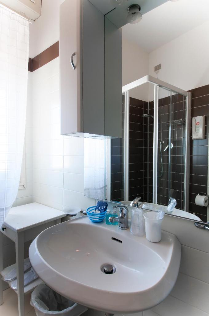 une salle de bain blanche avec un lavabo et un miroir dans l'établissement Hotel Telenia, à Lido di Jesolo