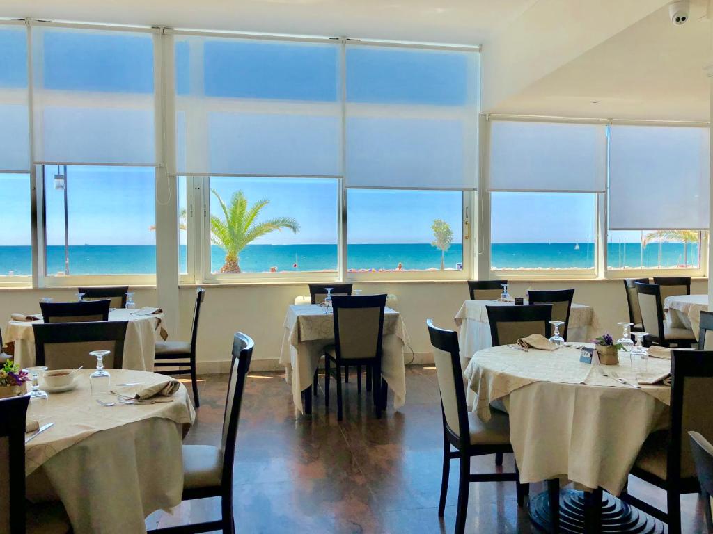 un restaurant avec tables et chaises avec vue sur l'océan dans l'établissement Hotel Villa Eleonora, à Scauri 66 autres photos
