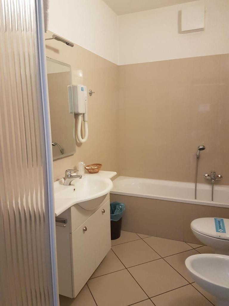 une salle de bain avec un lavabo, des toilettes et une baignoire dans l'établissement Hotel & Residence La Sibilla Cusiana, à Pettenasco