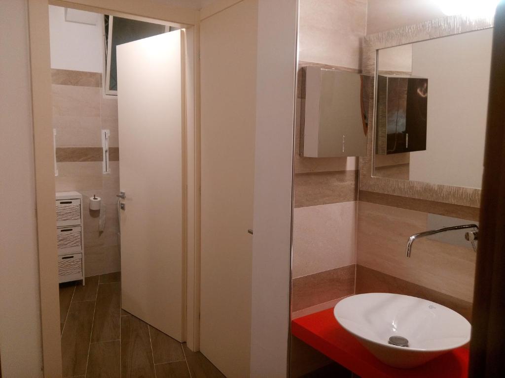 une salle de bain avec un lavabo blanc et un miroir dans l'établissement Hotel Telenia, à Lido di Jesolo 60 autres photos