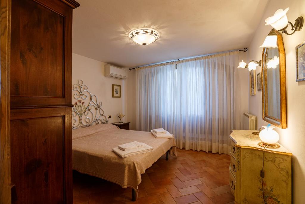 une chambre avec un lit, une commode et une fenêtre dans l'établissement villa Ada Belriguardo, à Sarteano 138 autres photos