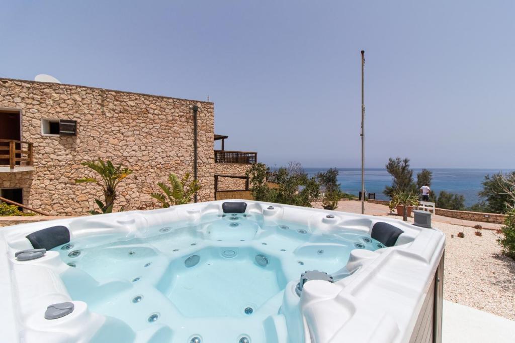 un jacuzzi sur une terrasse avec l'océan en arrière-plan dans l'établissement Relais Isole del Sud, à Lampedusa