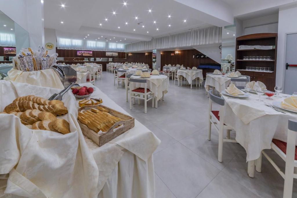 une salle à manger avec des tables et de la nourriture blanches dans l'établissement Eurhotel, à Rimini