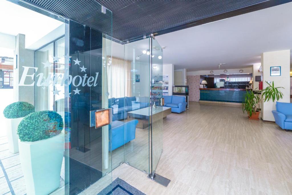 un bureau avec des chaises bleues et une paroi en verre dans l'établissement Eurhotel, à Rimini 70 autres photos