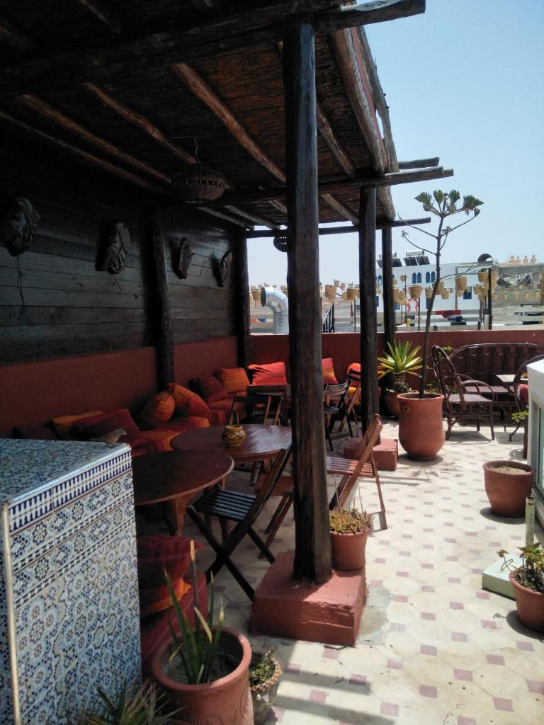 un patio extérieur avec des tables, des chaises et des plantes en pot dans l'établissement Caverne d'Ali Baba, à Essaouira
