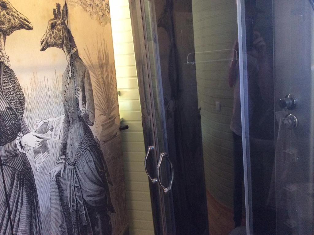 une salle de bains avec une peinture d'une femme dans une douche dans l'établissement Roulotte de luxe vue mer 180° ,et un ha de verdure, à Plougastel-Daoulas 14 autres photos