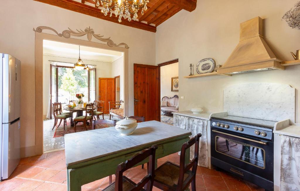 une cuisine avec une cuisinière et une table avec des chaises dans l'établissement Villa Contessa, à Bagni di Lucca