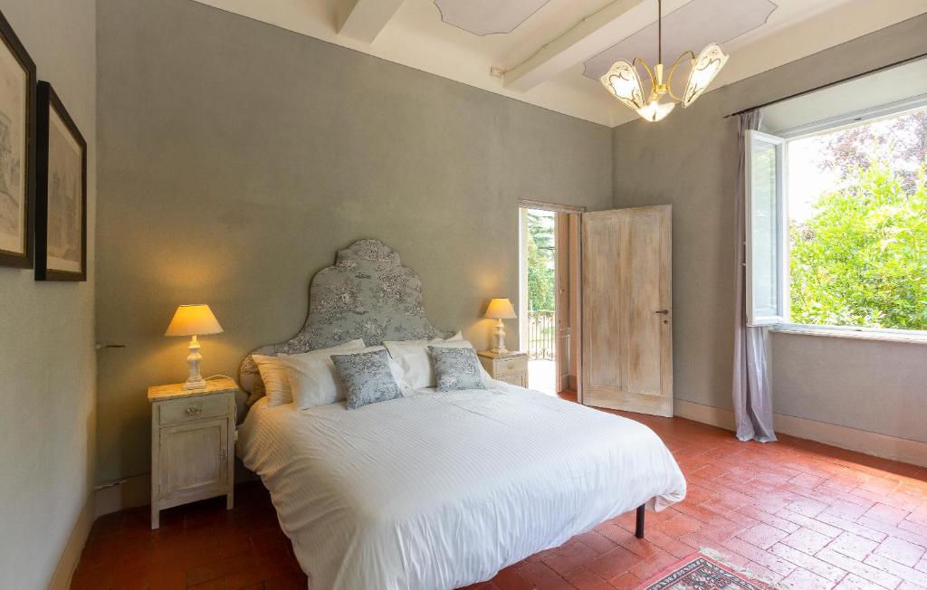 une chambre avec un lit blanc et une grande fenêtre dans l'établissement Villa Contessa, à Bagni di Lucca