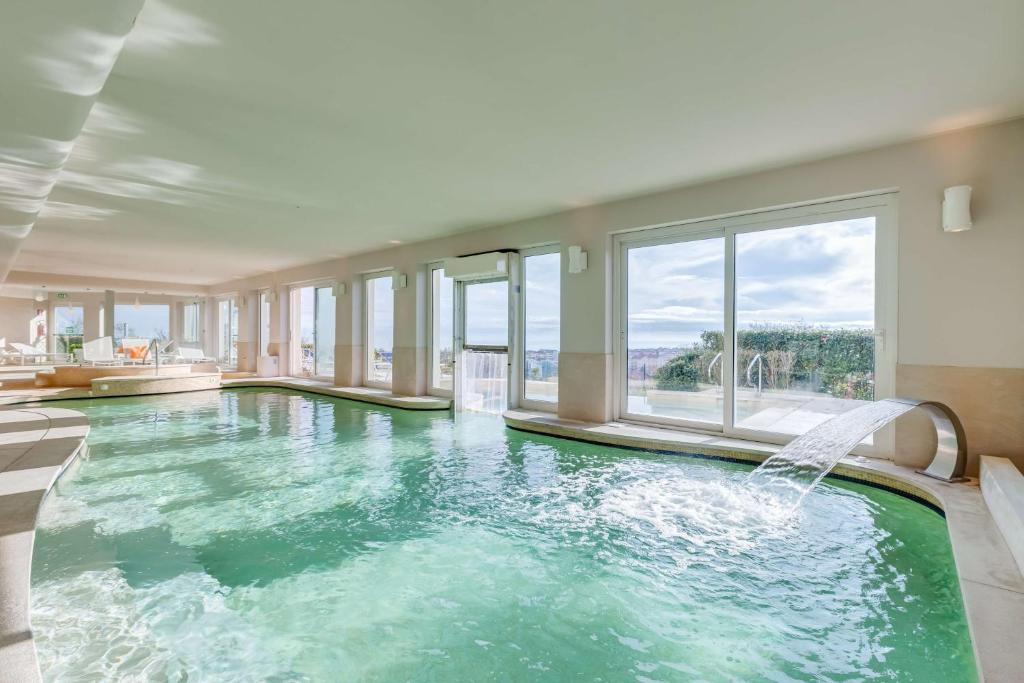 une piscine intérieure avec une fontaine dans l'établissement Villa Maria Hotel & SPA, à Francavilla al Mare