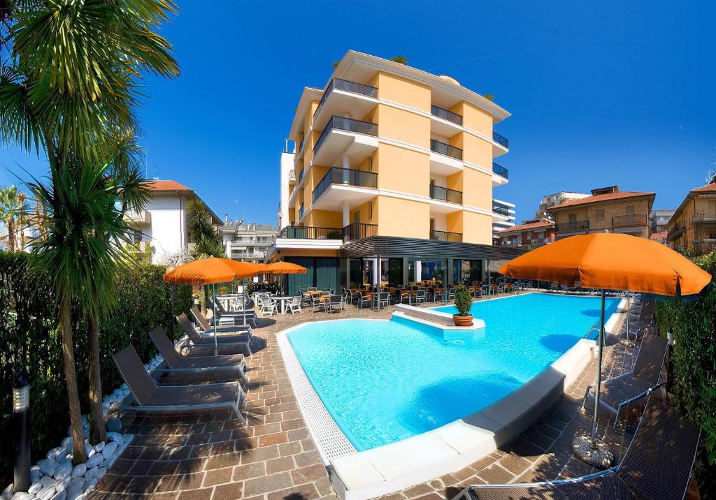 un hôtel avec une piscine dotée de chaises et de parasols dans l'établissement Hotel Imperial, à San Benedetto del Tronto