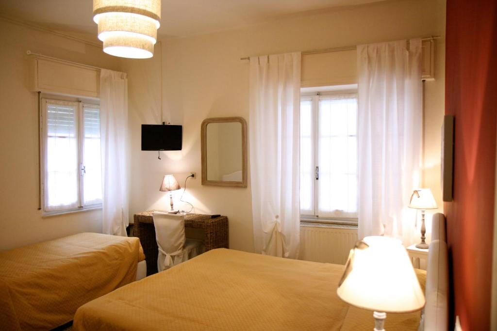 - une chambre avec 2 lits, un miroir et 2 fenêtres dans l'établissement Hotel Gabbiano, à Alassio