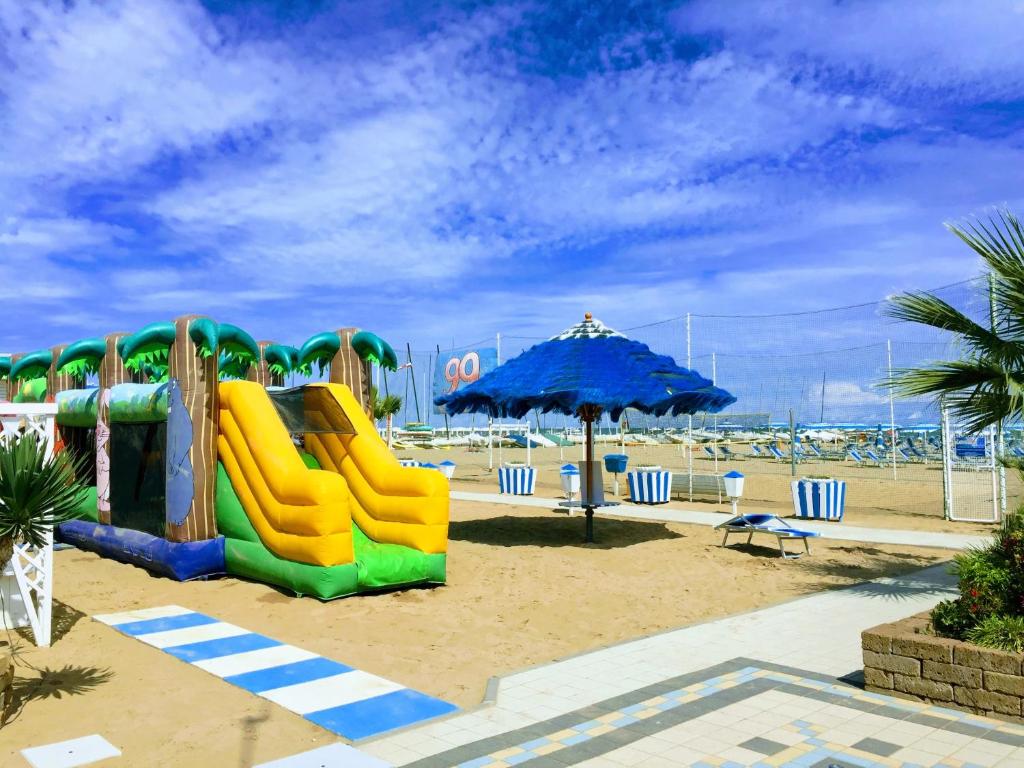 - une aire de jeux avec un toboggan et un parasol sur la plage dans l'établissement Residence Acqua Suite Marina, à Rimini