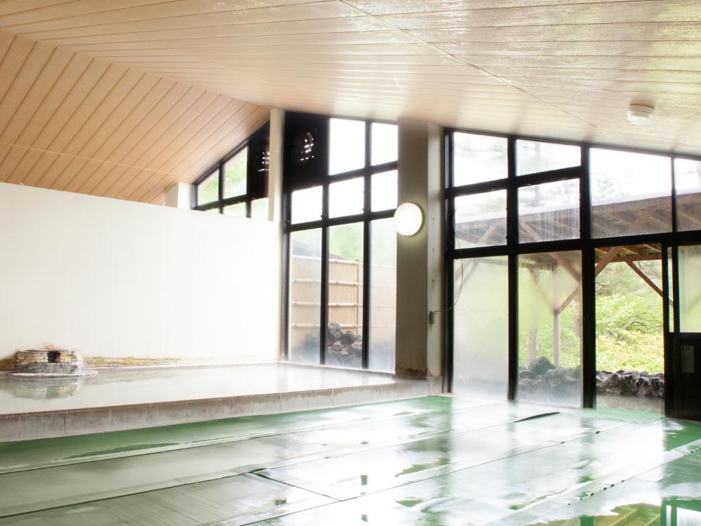 une pièce vide avec de grandes fenêtres et un sol dans l'établissement Hotel New Koyo, à Kusatsu