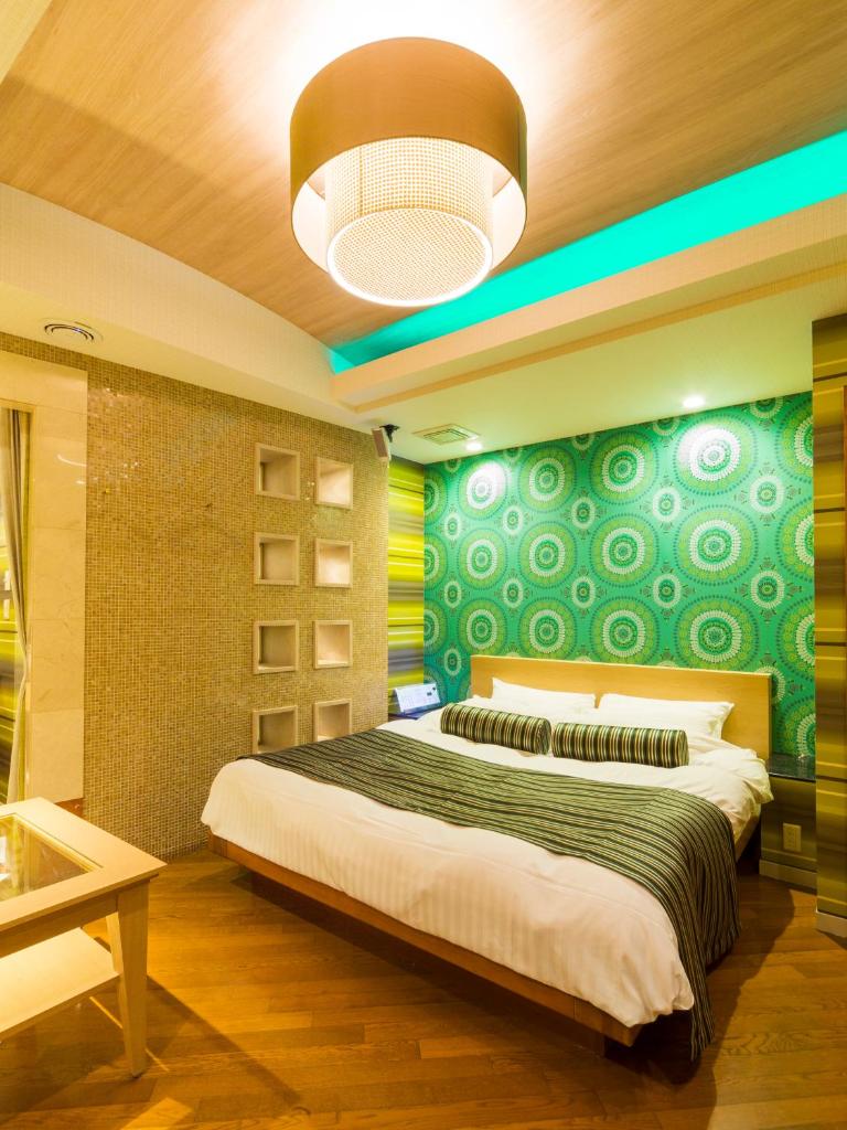 - une chambre dotée d'un lit avec un mur vert et jaune dans l'établissement Hotel Tosu Tsukasa (Love Hotel), à Tosu