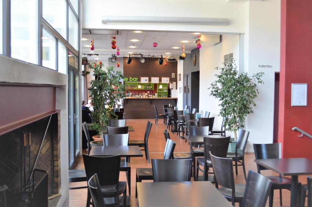 un restaurant avec des tables et des chaises et un bar dans l'établissement Village club de Bois d'Amont, à Bois-dʼAmont