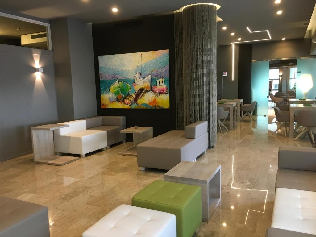un restaurant avec des canapés et des tables ainsi qu'une peinture murale dans l'établissement International Beach Hotel, à Lignano Sabbiadoro