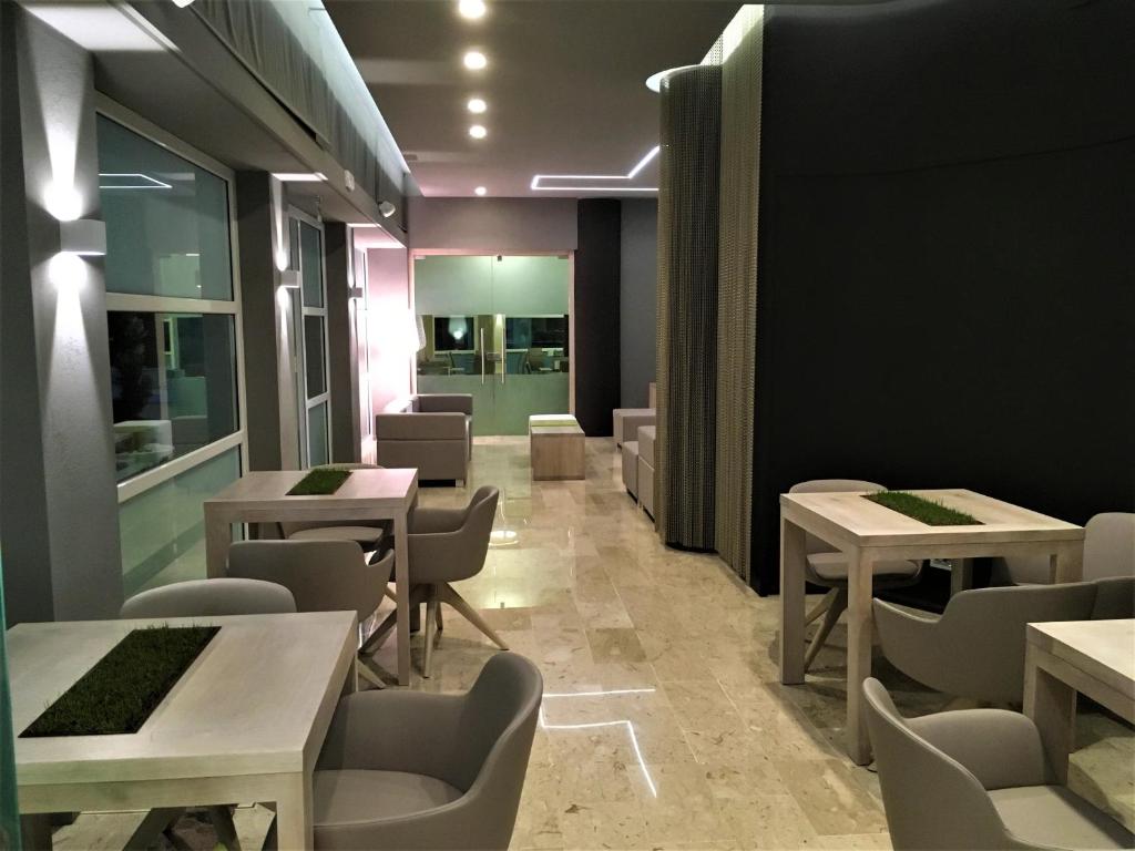 une salle à manger avec des tables, des chaises et des lumières dans l'établissement International Beach Hotel, à Lignano Sabbiadoro