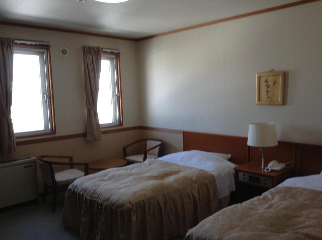 une chambre d'hôtel avec deux lits et deux fenêtres dans l'établissement Happokan, à Hakuba 34 autres photos