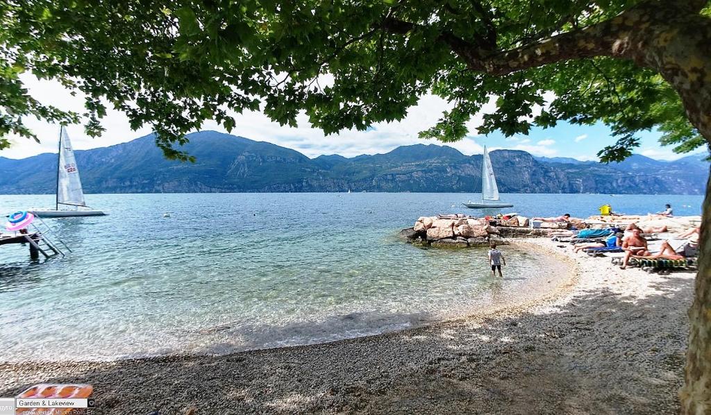 - une plage avec deux voiliers dans l'eau dans l'établissement Hotel Nike, à Brenzone