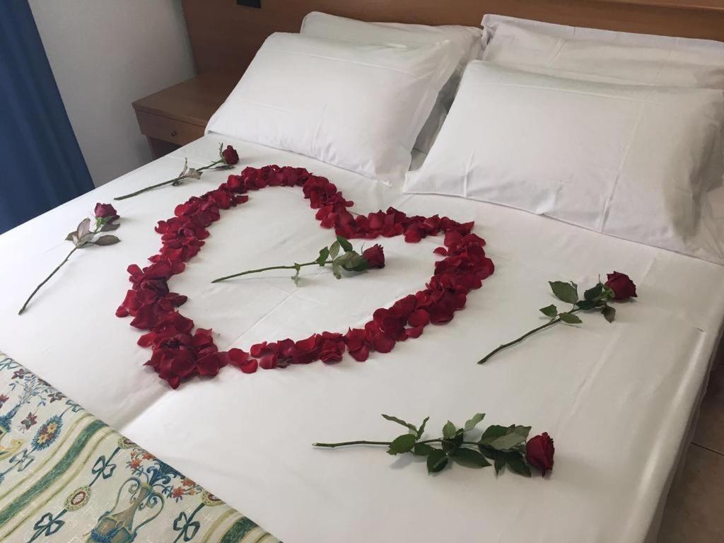 un cœur composé de roses sur un lit dans l'établissement Hotel Sole, à Eraclea Mare