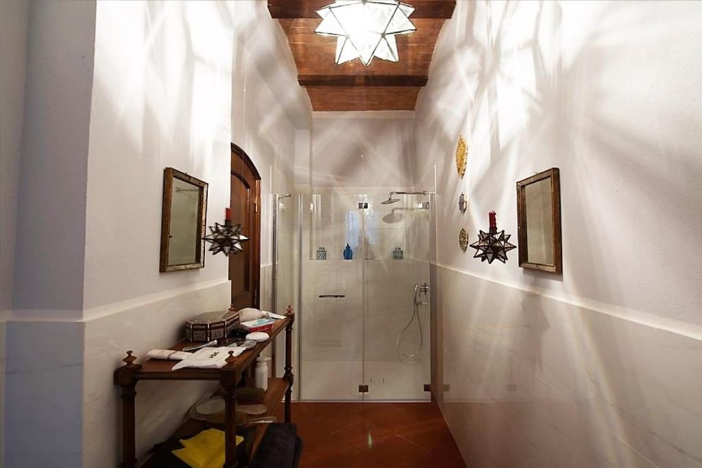 La salle de bains blanche est pourvue d'une douche et d'une table. dans l'établissement Villa Larniano, à Sienne